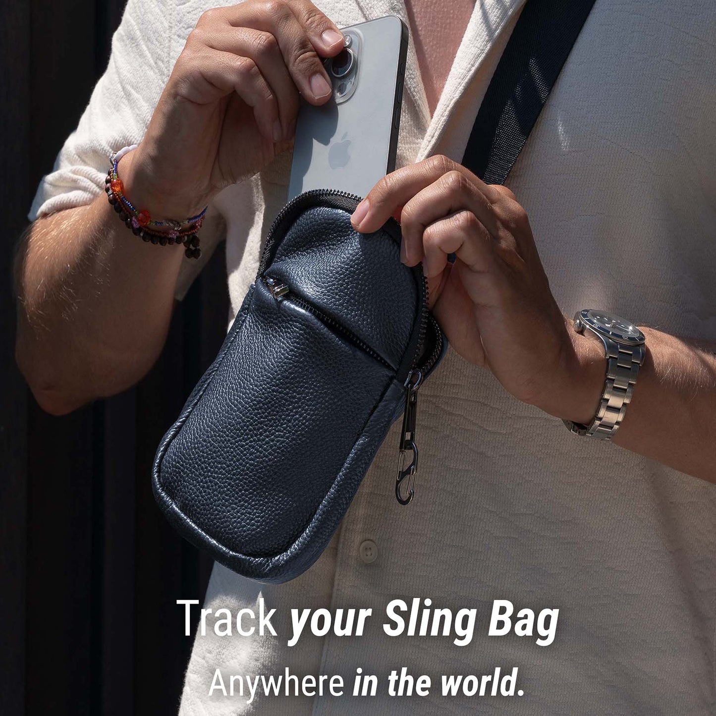 Person holding a black leather sling bag with a phone, with text 'Track your Sling Bag Anywhere in the world.'